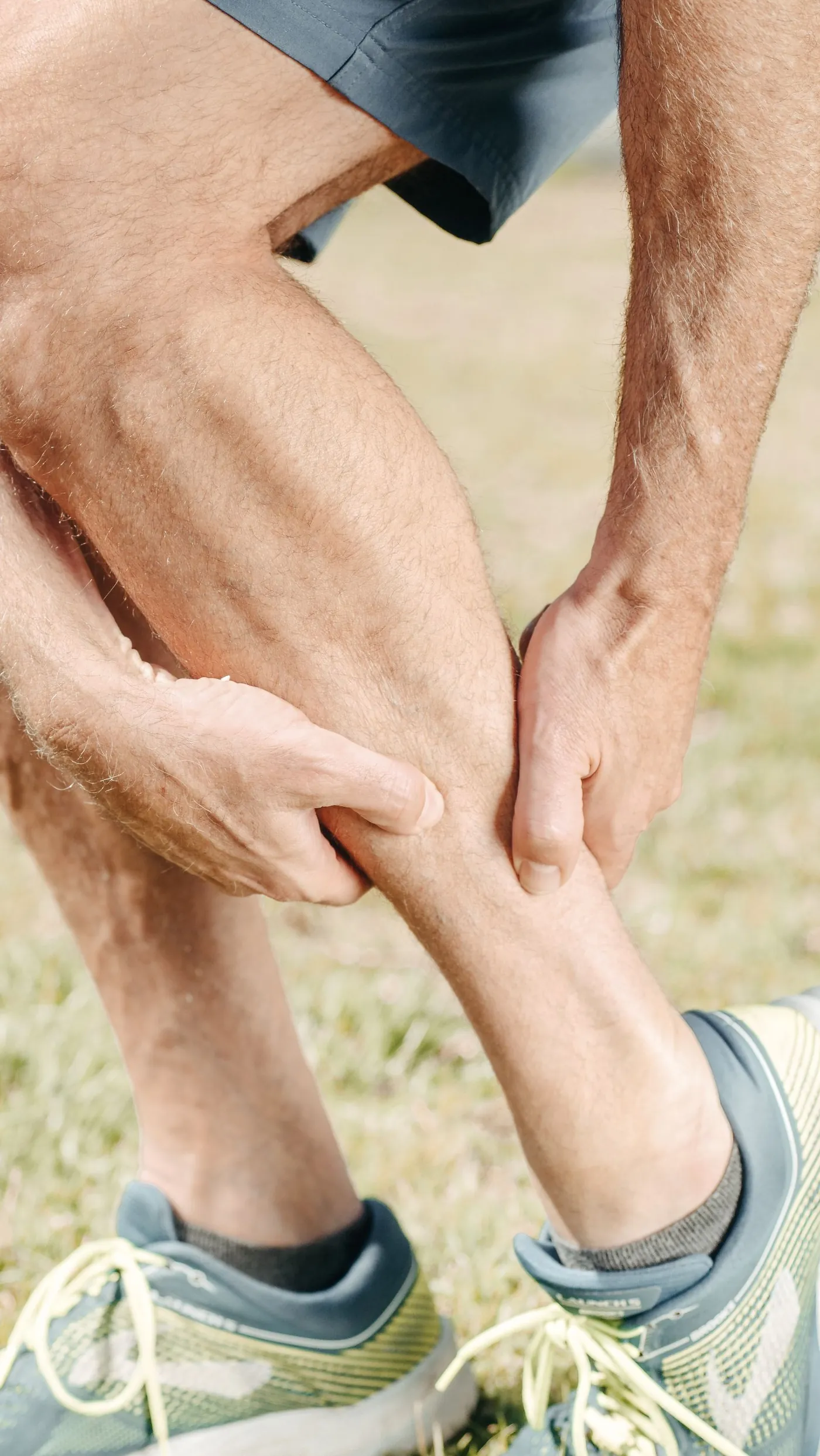 A runner holding his calf in pain